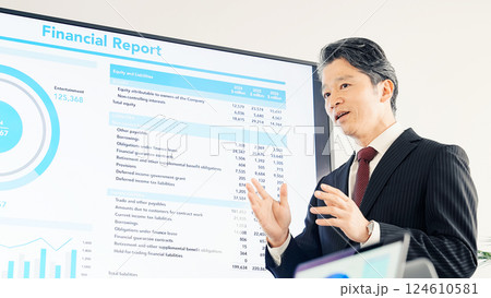 大画面モニターの前で説明するミドルエイジ男性ビジネスパーソン 大画面モニターの前で説明するミドルエイジ男性ビジネスパーソン 124610581