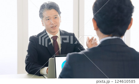オフィスで会議するミドルエイジ男性ビジネスパーソンのグループ オフィスで会議するミドルエイジ男性ビジネスパーソンのグループ 124610585