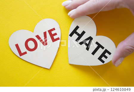 Love vs Hate symbol. Concept word Love vs Hate on wooden hearts. Businessman hand. Beautiful yellow background. Business and Love vs Hate concept. Copy space Love vs Hate symbol. Concept word Love vs Hate on wooden hearts. Businessman hand. Beautiful yellow background. Business and Love vs Hate concept. Copy space 124610849
