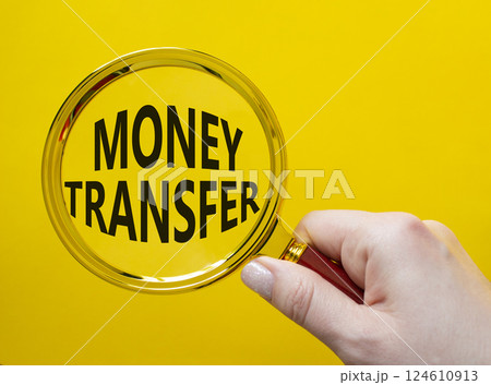 Money Transfer symbol. Magnifying Glass with Concept word Money Transfer. Businessman hand. Beautiful yellow background. Business and Money Transfer concept. Copy space Money Transfer symbol. Magnifying Glass with Concept word Money Transfer. Businessman hand. Beautiful yellow background. Business and Money Transfer concept. Copy space 124610913