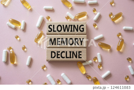 Slowing Memory Decline symbol. Concept words Slowing Memory Decline on wooden blocks. Beautiful pink background with pills. Healthcare and Slowing Memory Decline concept. Copy space. 124611083