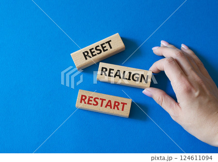 Reset Realign Restart symbol. Concept words Reset Realign Restart on wooden blocks. Businessman hand. Beautiful blue background. Business and Reset Realign Restart concept. Copy space. 124611094
