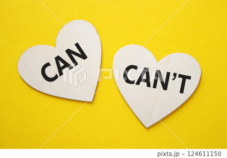 Can or Cant symbol. Concept word Can or Cant on wooden hearts. Beautiful yellow background. Business and Can or Cant concept. Copy space Can or Cant symbol. Concept word Can or Cant on wooden hearts. Beautiful yellow background. Business and Can or Cant concept. Copy space 124611150