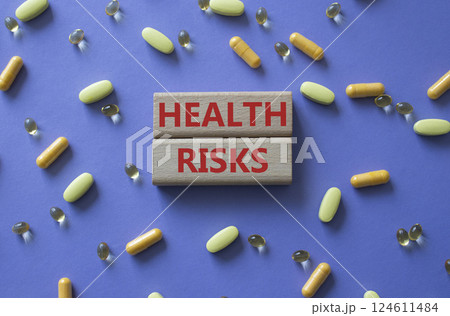 Health Risks symbol. Concept word Health Risks on wooden blocks. Beautiful purple background with pills. Medicine and Health Risks concept. Copy space Health Risks symbol. Concept word Health Risks on wooden blocks. Beautiful purple background with pills. Medicine and Health Risks concept. Copy space 124611484