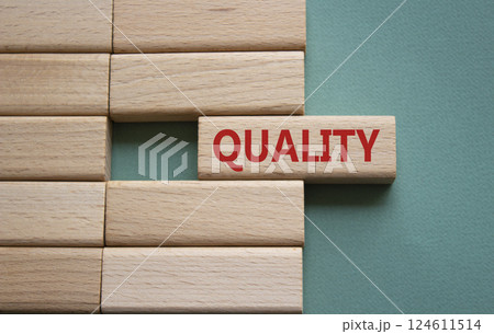 Quality symbol. Concept word Quality on wooden blocks. Beautiful grey green background. Business and Quality concept. Copy space. 124611514