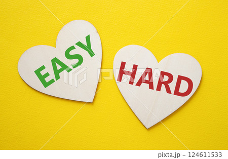 Easy or Hard symbol. Concept word Easy or Hard on wooden hearts. Beautiful yellow background. Business and Easy or Hard concept. Copy space 124611533