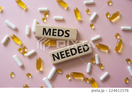Meds Needed symbol. Concept word Meds Needed on wooden blocks. Beautiful pink background with pills. Medicine and Meds Needed concept. Copy space 124611576