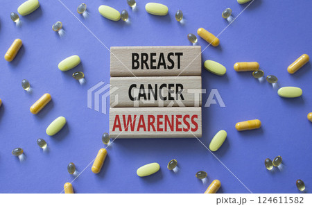 Breast Cancer Awareness symbol. Concept word Breast Cancer Awareness on wooden blocks. Beautiful purple background with pills. Medicine and Breast Cancer Awareness concept. Copy space 124611582