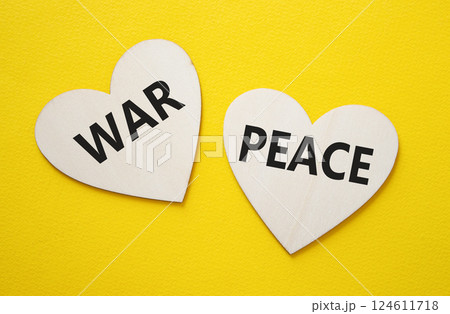 War or Peace symbol. Concept word War or Peace on wooden hearts. Beautiful yellow background. Business and War or Peace concept. Copy space War or Peace symbol. Concept word War or Peace on wooden hearts. Beautiful yellow background. Business and War or Peace concept. Copy space 124611718