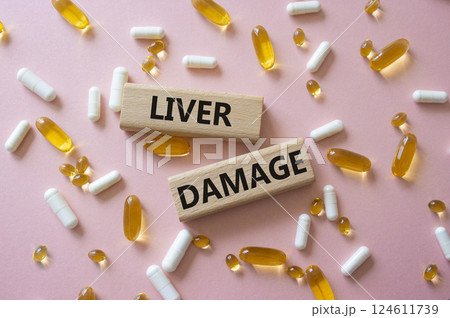 Liver Damage symbol. Concept word Liver Damage on wooden blocks. Beautiful pink background with pills. Medicine and Liver Damage concept. Copy space 124611739