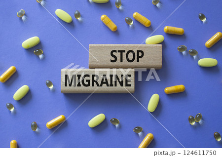 Stop Migraine symbol. Concept word Stop Migraine on wooden blocks. Beautiful purple background with pills. Medicine and Stop Migraine concept. Copy space 124611750