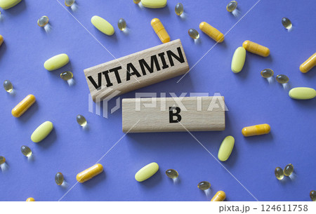 Vitamin B symbol. Concept word Vitamin B on wooden blocks. Beautiful purple background with pills. Medicine and Vitamin B concept. Copy space 124611758