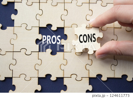 Pros vs Cons symbol. Concept word Pros vs Cons on wooden puzzle. Businessman hand. Beautiful deep blue background. Business and Pros vs Cons concept. Copy space 124611773