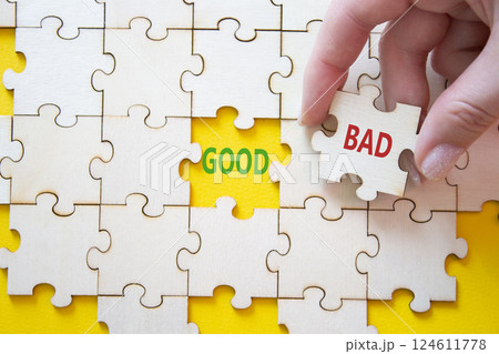 Good or Bad symbol. Concept word Good or Bad on wooden puzzle. Businessman hand. Beautiful yellow background. Business and Good or Bad concept. Copy space 124611778