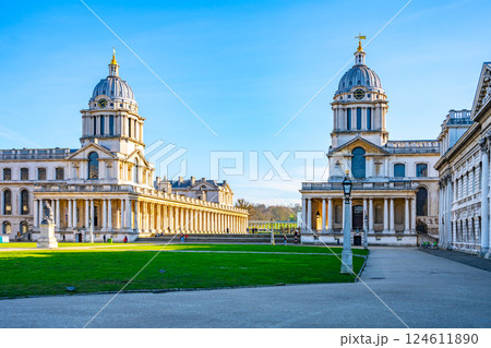Historical architecture at Greenwich Campus showcases stunning designs amidst green lawns. Visitors enjoy the landscape, highlighting London's rich heritage and educational environment. 124611890