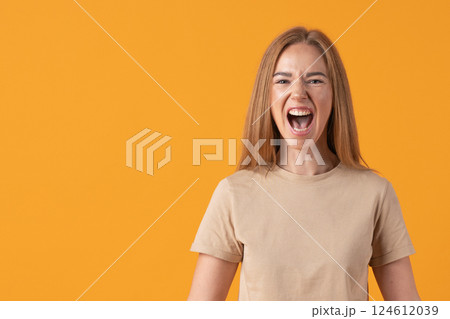 Joyful Woman Shouting on Orange Background 124612039