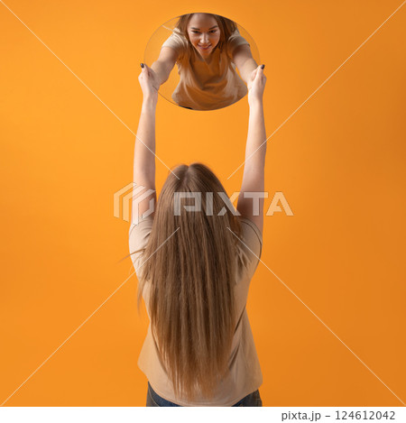 Woman Reflecting in Circular Mirror 124612042