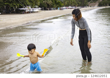 Mother And Child Walk In Beach With Washing Their Feet Mother And Child Walk In Beach With Washing Their Feet 124612051