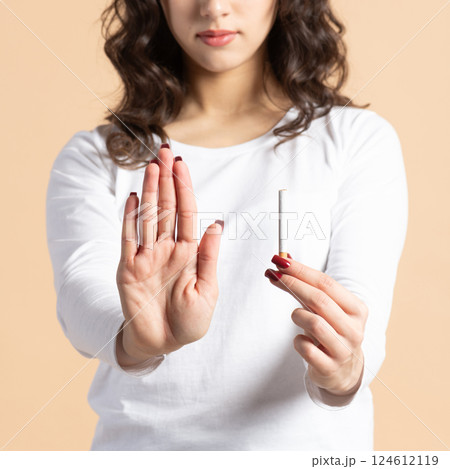 Woman with cigarette and no smoking hand palm sign Woman with cigarette and no smoking hand palm sign 124612119