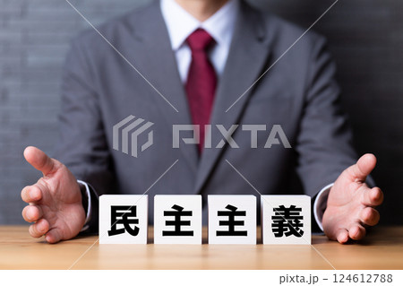 民主主義のブロックとスーツを着たミドル男性ビジネスマン 民主主義のブロックとスーツを着たミドル男性ビジネスマン 124612788