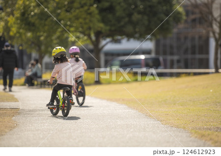 公園で自転車に乗って遊ぶ女の子の後ろ姿 124612923