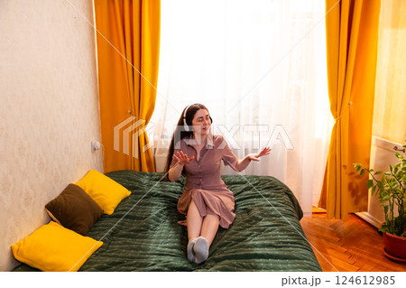 Joyful young woman swaying to the melody, fully present in her happiness. Wide shot Joyful young woman swaying to the melody, fully present in her happiness. Wide shot 124612985