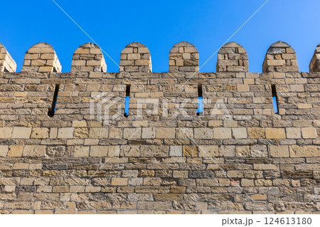 Historic stone wall featuring crenellations and arrow slits, Baku old town 124613180
