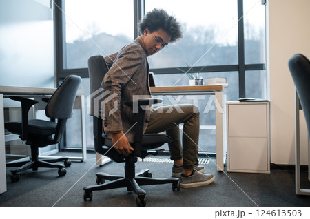 Businessman wearing suit sitting on armchair resting in modern office room 124613503