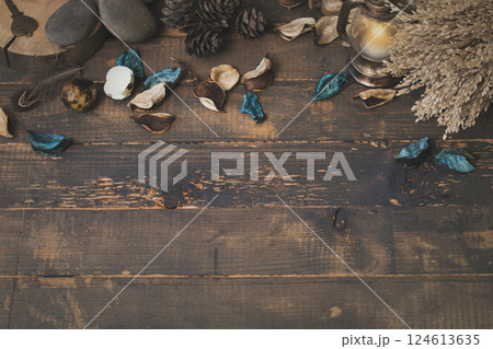 Witchcraft atmospheric set. Dry herbs, blue flower petals, stones, small lantern, old key, birds feather on rude wooden surface, copy space. 124613635