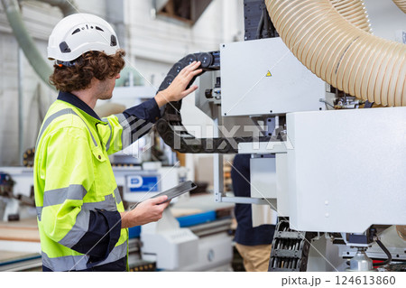 Young worker control operate wood cutter CNC machine in furniture factory industry with safety Young worker control operate wood cutter CNC machine in furniture factory industry with safety 124613860