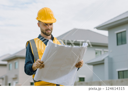 Construction worker happy smile. Engineer male wearing safety vest and helmet at construction site 124614315