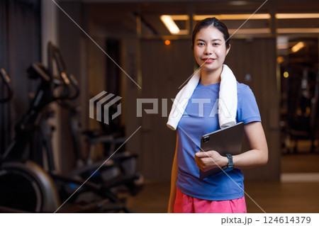 portrait personal trainer, healthy women standing with tablet at private luxury sport center gym 124614379