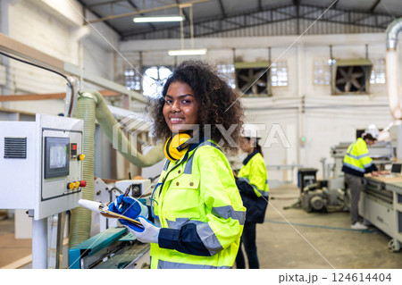 African black women worker work with wood cutter machine furniture factory industry with safety suit African black women worker work with wood cutter machine furniture factory industry with safety suit 124614404