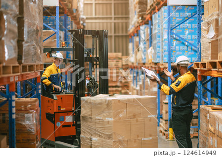 Warehouse worker in duty stock control by forklift truck moving products cargo inventory management Warehouse worker in duty stock control by forklift truck moving products cargo inventory management 124614949