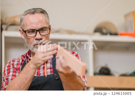 Professional carpenter man working with wood piece design furniture in workshop in wood factory Professional carpenter man working with wood piece design furniture in workshop in wood factory 124615005