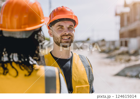 Construction worker happy smile. Engineer male wearing safety vest and helmet at construction site Construction worker happy smile. Engineer male wearing safety vest and helmet at construction site 124615014