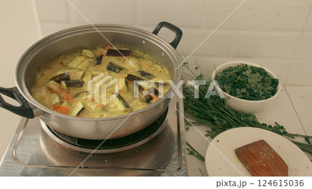 A pot of ginataang gulay cooking on a stove, a traditional local Filipino food made of vegetable cooked in coconut milk stew showing the culture and cuisine of the Philippines 124615036