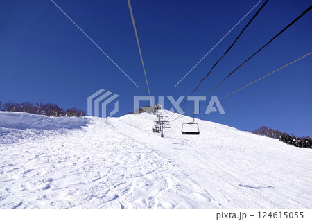 快晴のスキー場 頂上へ続くリフトと広い真っ白なゲレンデ 快晴のスキー場 頂上へ続くリフトと広い真っ白なゲレンデ 124615055