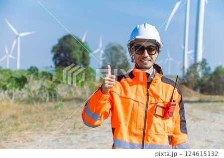 Portrait engineer worker standing hand thumbs up at wind turbine energy farm outdoor happy smile. Portrait engineer worker standing hand thumbs up at wind turbine energy farm outdoor happy smile. 124615132