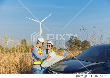 Engineer workers teamwork site survey at wind turbine farm project planning construction together. 124615157