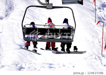 快晴のスキー場 頂上へ続くリフトに乗る家族 快晴のスキー場 頂上へ続くリフトに乗る家族 124615396