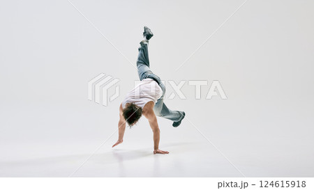 Hip-hop, dancer executing gravity-defying handstand spin with fluid motion against white background. Concept of music and dance. 124615918
