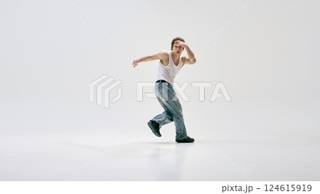 Passionate dancer dancing in motion, showing energy, combining physical artistry with urban dance elements against white background. Passionate dancer dancing in motion, showing energy, combining physical artistry with urban dance elements against white background. 124615919