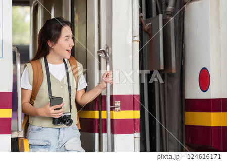Exploration and Travel Moments. A traveler joyfully stepping out of a train, ready for new experiences. Exploration and Travel Moments. A traveler joyfully stepping out of a train, ready for new experiences. 124616171