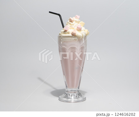 Creamy Pink Milkshake in Glass Topped with Whipped Cream, Marshmallows and Straw Isolated on Light Background 124616202