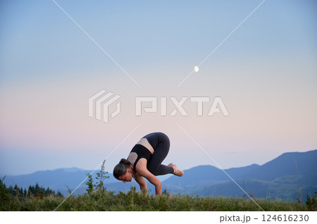 Woman practicing yoga outdoors in the mountains in a serene, natural setting. Female performing yoga pose, with backdrop of beautiful mountain landscape at sunrise or sunset. Woman practicing yoga outdoors in the mountains in a serene, natural setting. Female performing yoga pose, with backdrop of beautiful mountain landscape at sunrise or sunset. 124616230