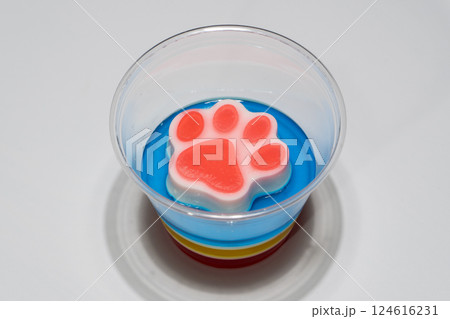 Colorful Layered Dessert Jelly Cup with Paw Shaped Topper on White Background Colorful Layered Dessert Jelly Cup with Paw Shaped Topper on White Background 124616231