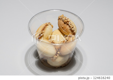 Delicious Nut-Filled Cookie Sandwiches in a Transparent Plastic Cup on White Surface Delicious Nut-Filled Cookie Sandwiches in a Transparent Plastic Cup on White Surface 124616240
