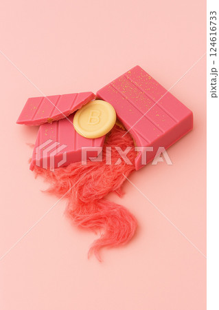 A broken pink chocolate bar with fibrous filling on a pink background. pink pismaniye. Trendy sweets. angel hair 124616733
