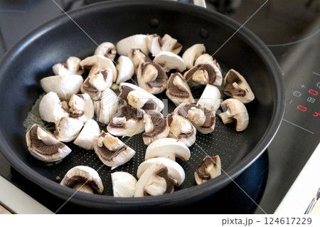Raw champignon mushrooms in a frying pan ready for frying Raw champignon mushrooms in a frying pan ready for frying 124617229